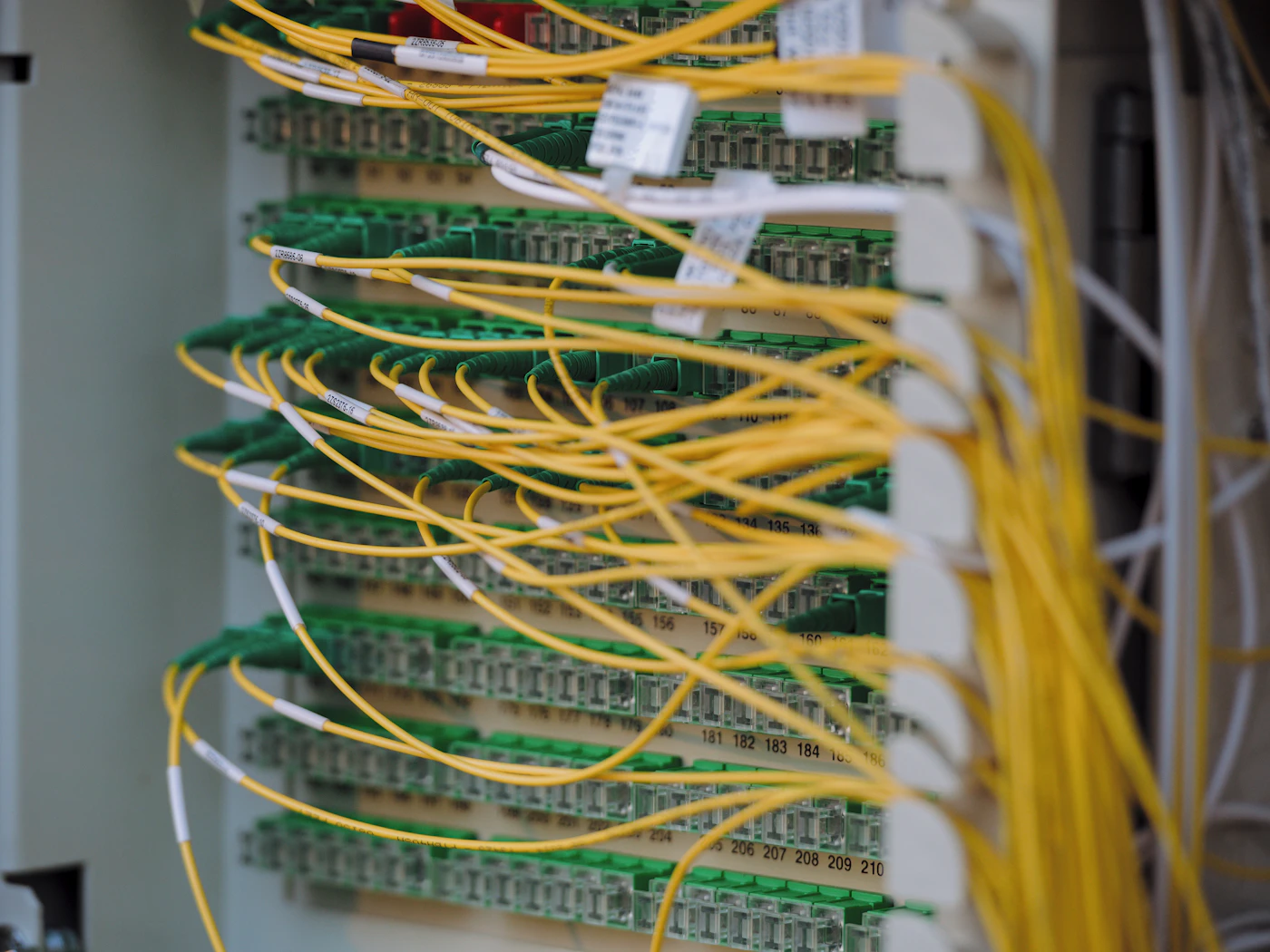 A network patch panel with dense bundles of yellow and green fibre cables.